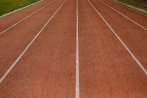 An empty running track with clearly marked white lanes on a sunny day, ready for sports activities. jigsaw puzzle