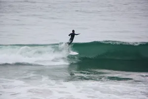 Surfer catches a wave, skillfully balancing on a surfboard amidst ocean waves. jigsaw puzzle