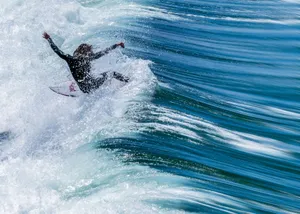 Exciting shot of a surfer catching a wave, showcasing action and skill in vibrant ocean waters. jigsaw puzzle