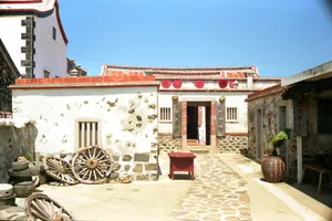 Explore the vintage stone courtyard of a traditional house in Taiwan under a clear blue sky. jigsaw puzzle