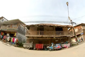 Rustic wooden house on a sunny day in a quaint old town with street market and vintage scooter. jigsaw puzzle