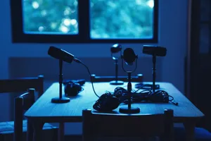 Dimly lit podcast studio with microphones and headphones on a table. jigsaw puzzle