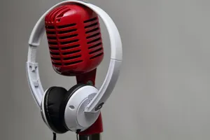 Close-up of a red vintage microphone with white headphones against a gray background. jigsaw puzzle