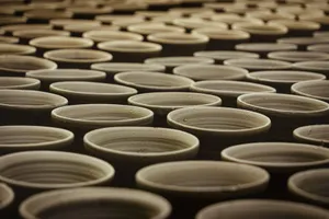 Multiple handcrafted clay pots aligned in a traditional pottery workshop. jigsaw puzzle