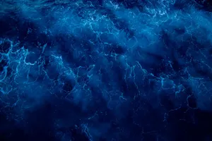 A mesmerizing top view of dark blue ocean waves with a wavy surface and intricate texture. jigsaw puzzle