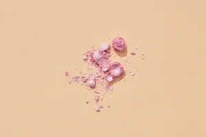 Crushed pink makeup powder scattered on a light beige background, perfect for beauty and cosmetic themes. jigsaw puzzle