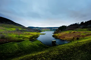 a body of water surrounded by a lush green hillside jigsaw puzzle
