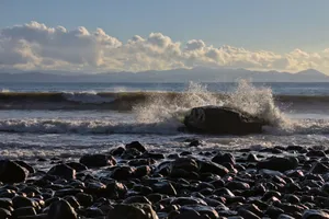 a large rock sitting on top of a beach next to the ocean jigsaw puzzle