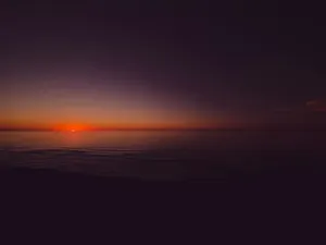 the sun is setting over the ocean on a cloudy day jigsaw puzzle