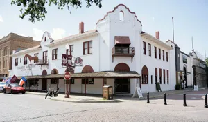 a white building with red trim on a street corner jigsaw puzzle