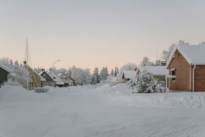a snow covered street with houses in the background jigsaw puzzle