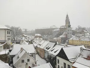 a snowy view of a city with buildings and a clock tower jigsaw puzzle