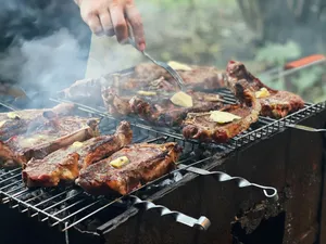 a person is cooking steaks on a grill jigsaw puzzle