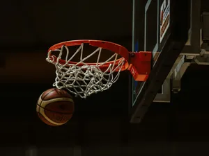 A basketball going through the hoop in a basketball court jigsaw puzzle
