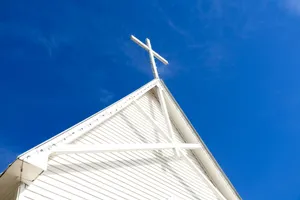 A white church steeple and cross against a blue sky. jigsaw puzzle