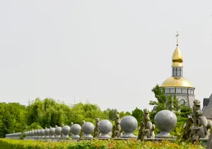 A golden-topped tower stands behind a stone wall. jigsaw puzzle