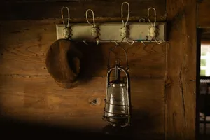 A hat and lantern hang on a rustic wooden wall. jigsaw puzzle