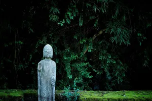 Peaceful Buddha statue set against a vibrant green backdrop, evoking tranquility. jigsaw puzzle