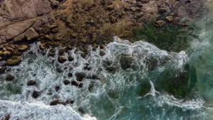 Stunning aerial photo capturing waves crashing against a rocky shore. jigsaw puzzle