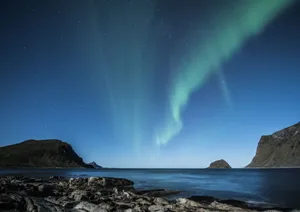 A breathtaking view of the aurora borealis above the rocky coast of Lofoten, Norway at night. jigsaw puzzle