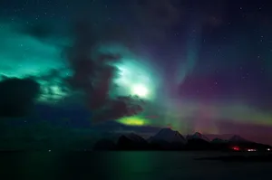 Stunning display of Aurora Borealis illuminating snow-capped mountains in Nordland, Norway. jigsaw puzzle