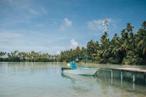Idyllic lagoon view with a boat, palm trees, and blue sky at Kolhufushi, Maldives. jigsaw puzzle