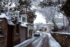 Charming snow-covered street in a tranquil town, showcasing winter beauty. jigsaw puzzle