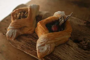 Close-up of artisan Danish pastries topped with fresh fruit and nuts on a wooden board. jigsaw puzzle