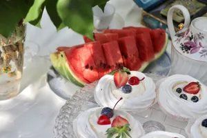 Colorful summer dessert table featuring watermelon slices and berry-topped pastries. jigsaw puzzle