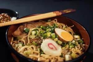 Bowl of traditional Japanese ramen with boiled egg, scallions, and narutomaki served with chopsticks. jigsaw puzzle