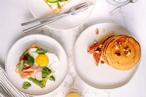 Top view of breakfast plates featuring pancakes and toast with eggs and vegetables. jigsaw puzzle