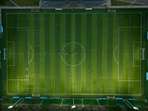 Top-down view of a soccer field with players during daytime. jigsaw puzzle