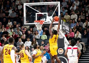A player jumps to score during a thrilling basketball game with a full crowd. jigsaw puzzle