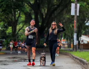 Two adults in sportswear jogging with a dog on a paved path in Risaralda, Colombia. jigsaw puzzle