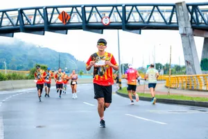 Marathon runners in colorful shirts race under a bridge on a city street. jigsaw puzzle