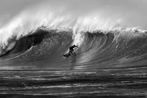 A stunning black and white photograph capturing a surfer skillfully navigating a massive wave. jigsaw puzzle