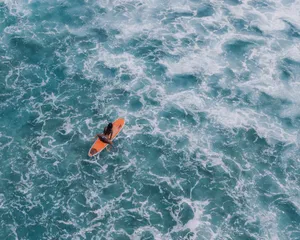 Action-packed aerial shot of a surfer riding waves in Hawaii's blue ocean waters. jigsaw puzzle