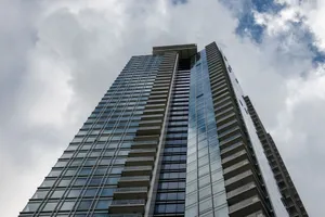Low angle view of a modern skyscraper reaching into a cloudy sky, representing urban architecture. jigsaw puzzle