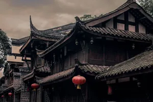 Historic Chinese building with ornate roofs and red lanterns under cloudy skies. jigsaw puzzle