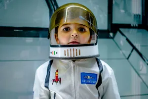 Cute boy with brown eyes wearing captain space costume and helmet and looking away jigsaw puzzle