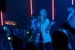 A captivating live concert performance by a female vocalist with neon lighting effects. jigsaw puzzle