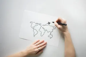 Hands drawing world map on paper, representing travel and creativity concepts. jigsaw puzzle