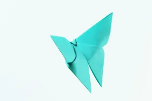 A vibrant blue origami butterfly crafted from paper on a white background. jigsaw puzzle