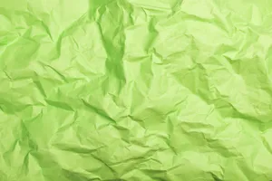 A detailed close-up of a crumpled green paper showcasing unique texture and folds. jigsaw puzzle