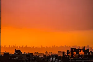 Capture the beauty of an urban skyline at sunset with warm orange hues and silhouetted buildings. jigsaw puzzle
