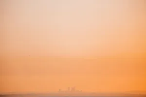 Silhouette of a city skyline shrouded in orange fog during a sunset. jigsaw puzzle