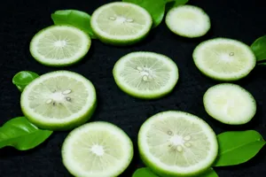 Round green lime slices arranged with fresh leaves on a dark background. jigsaw puzzle