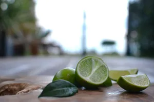 Close-up of sliced limes with a blurred outdoor background, capturing freshness and nature. jigsaw puzzle