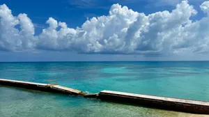 Calm turquoise ocean water under a cloudy blue sky. jigsaw puzzle
