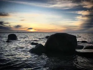 a large rock sitting in the middle of a body of water jigsaw puzzle